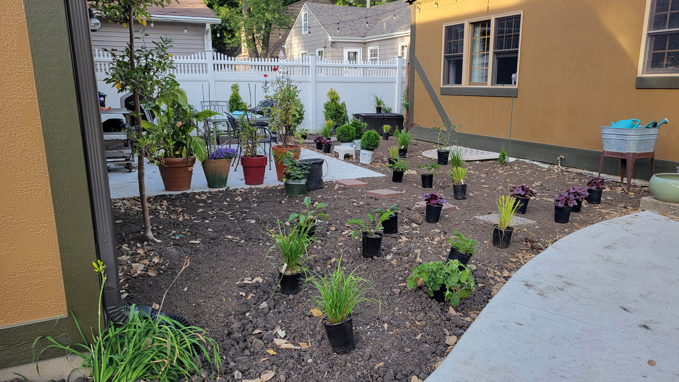 new garden bed with plants mapped out in pots