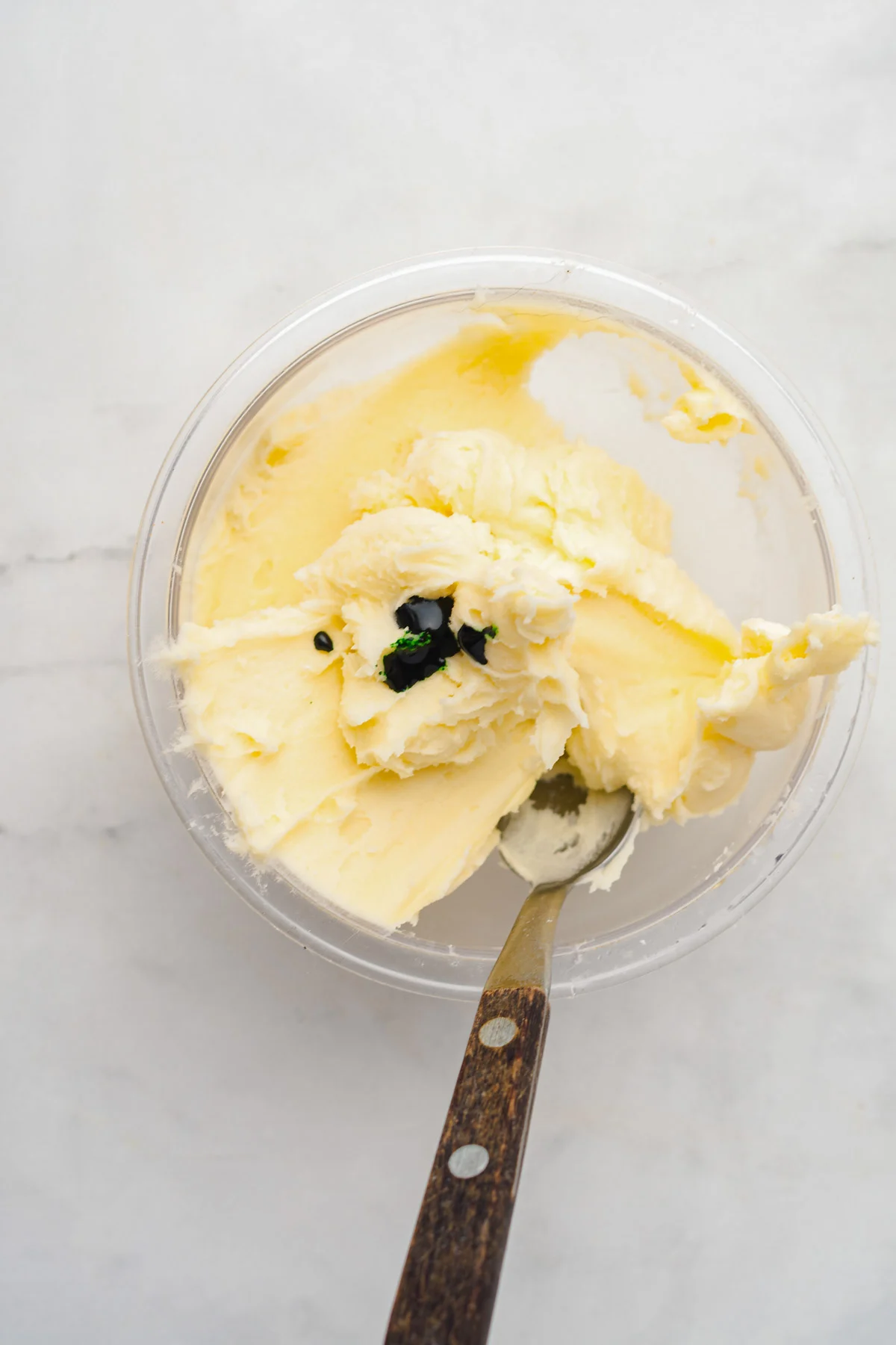 mixing green buttercream frosting to use for creating ice cream cone christmas trees for cake