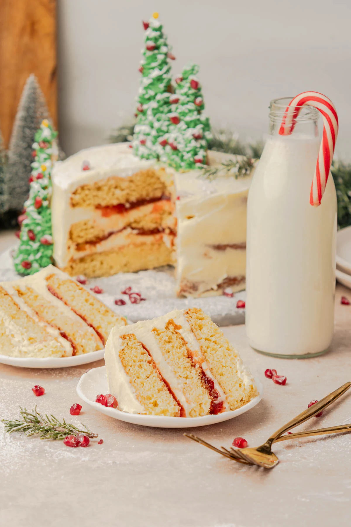 two slices of christmas cake with red cranberry filling and a glass of milk