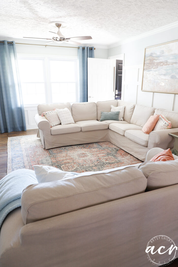 evolution of a living room 5 blue curtains, tan couch, colorful couch