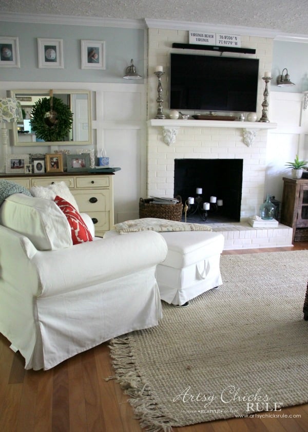 evolution of a living room 9 blue and white walls fireplace with tv over, white chair and ottoman