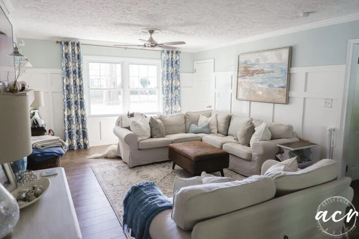 evolution of a living room 6 blue patterned curtains, brown tan and blue colored rug, tan furniture, blue and white walls