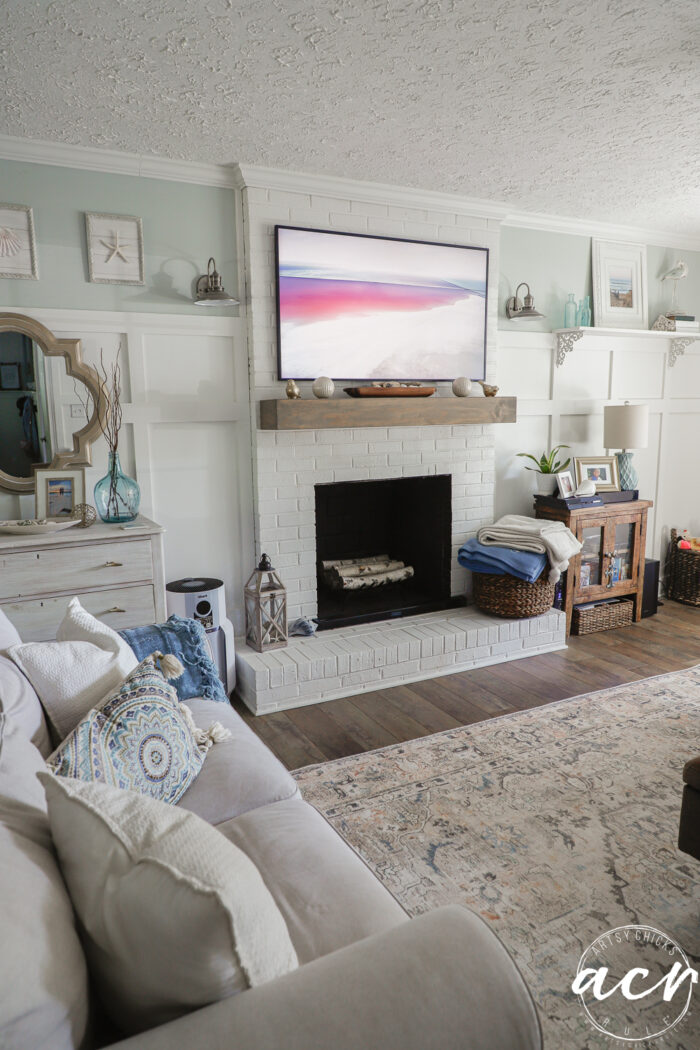 evolution of a living room 13 frame tv over fireplace with photo on it, tan couch
