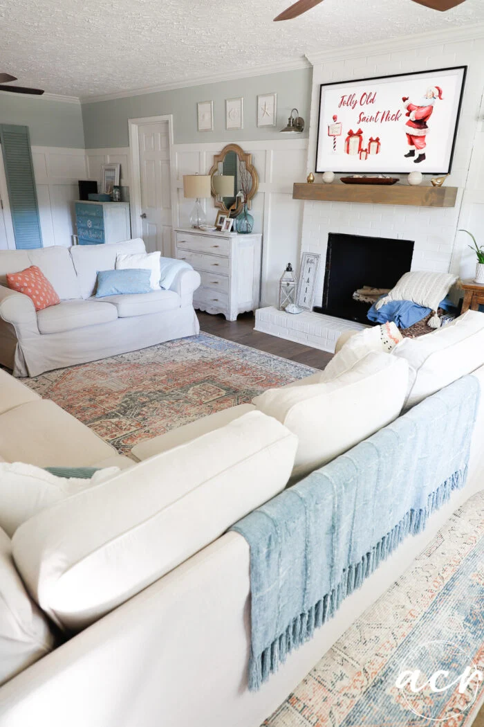 evolution of a living room 17 tan sectional, fireplace, blue throw and red and coral rug