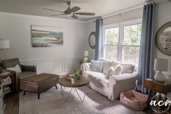 artwork and couch blue curtains and painted ceiling