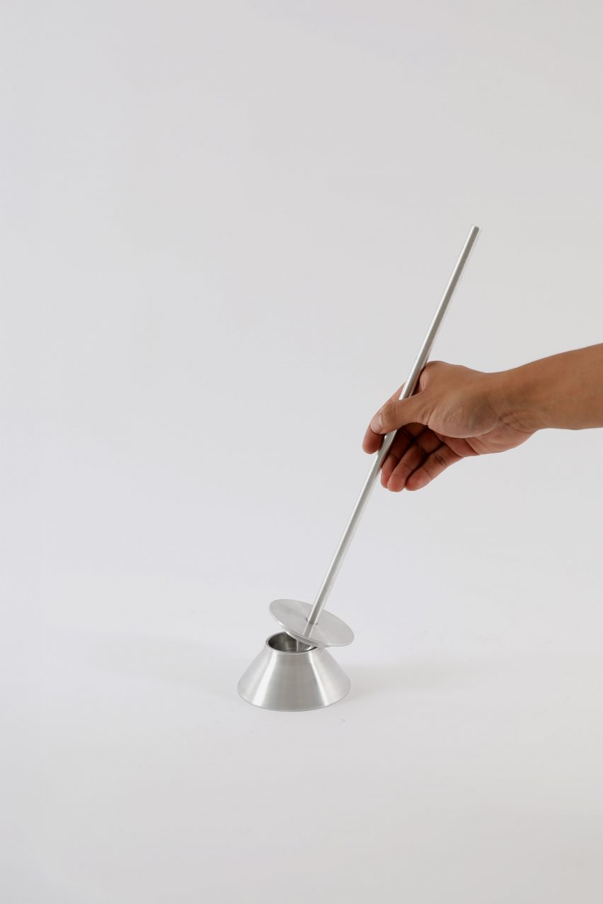 a photograph of a person handing a silver tool