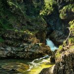 —Metaphor: Stones as ancient, cradling sanctuary amid peaks.