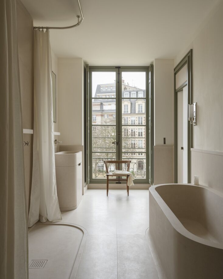 both the bath and minimalist shower are cut from the same beige fine stone as t 22