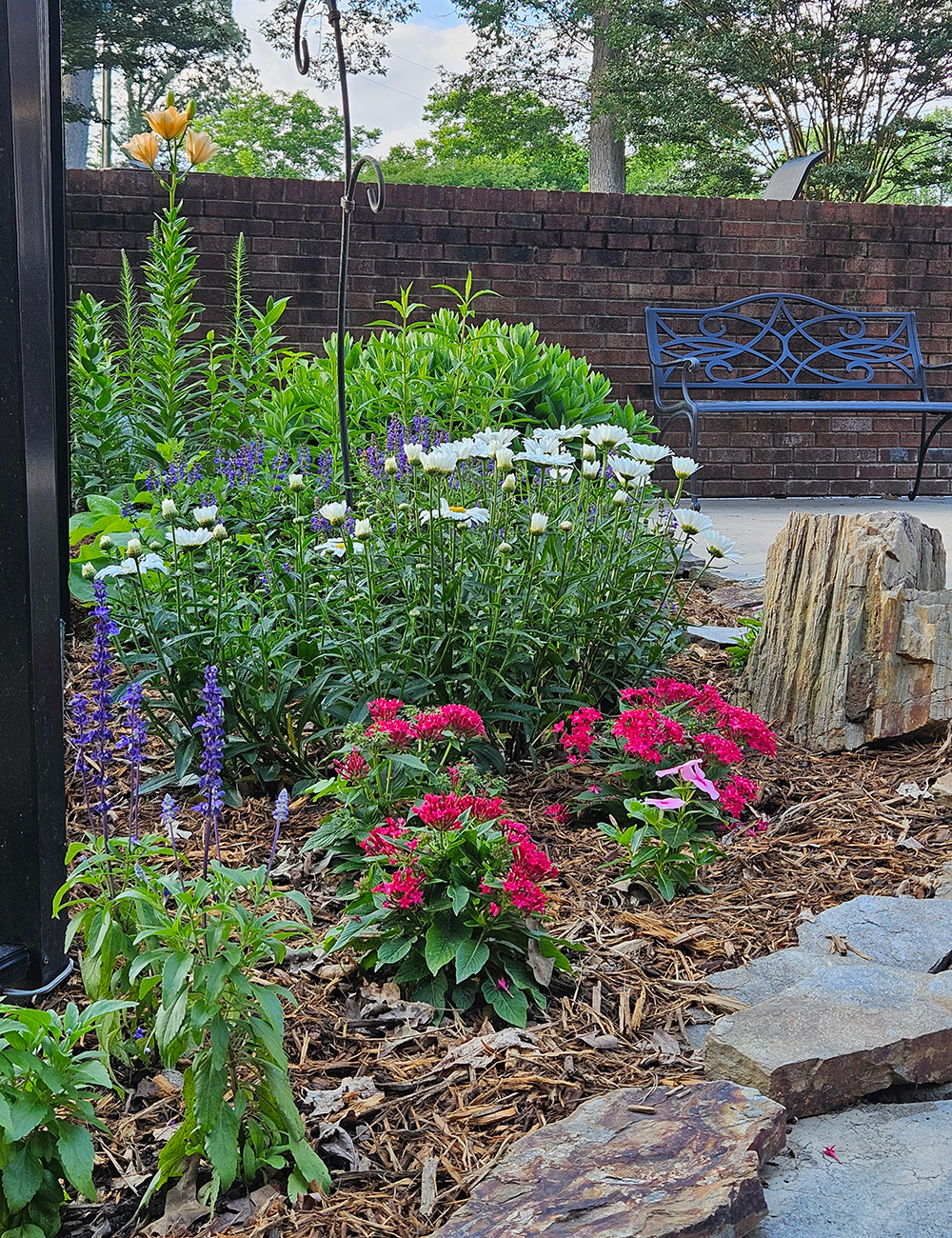 small corner garden bed with flowers