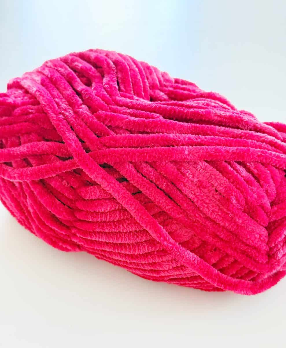 diy christmas tassel simple stepbystep tutorial 37 a close-up of a skein of bright pink chenille yarn resting on a white surface. the texture appears soft and plush, with thick, velvety strands—perfect for projects like how to make a giant bow.