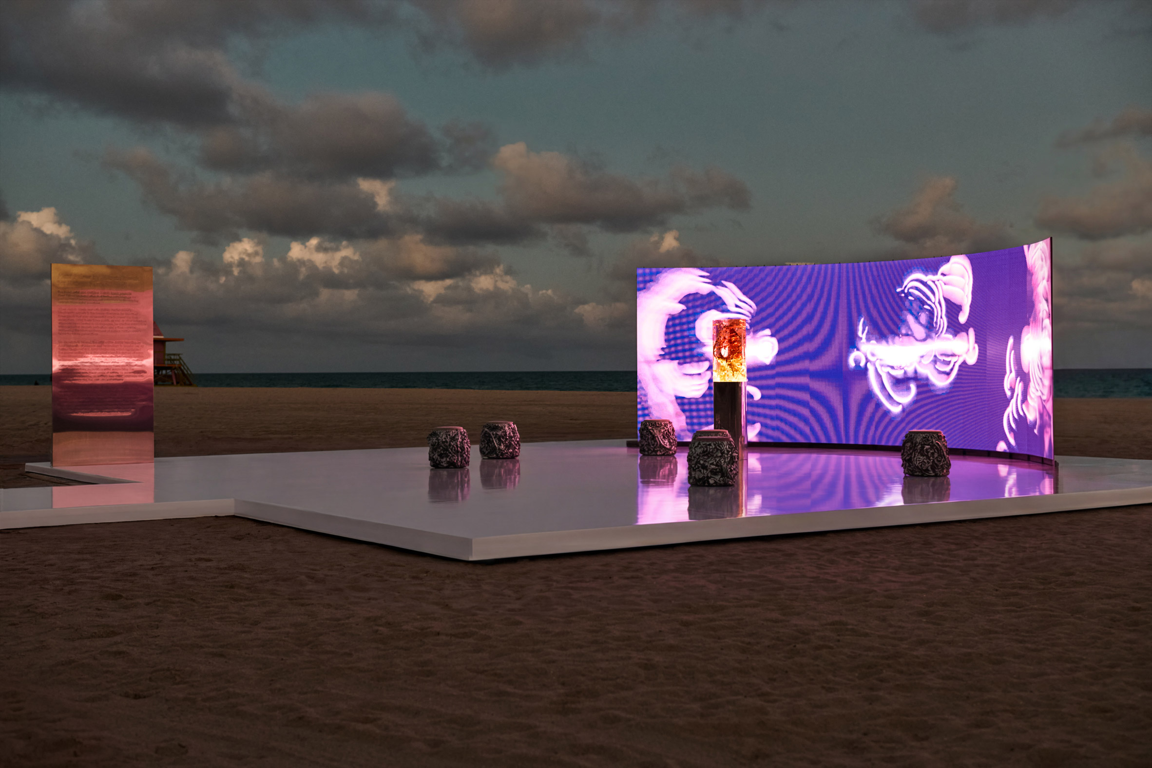 wide view of the plant pulses installation on miami beach with the led backdrop, resin sculpture and textured stools at dusk