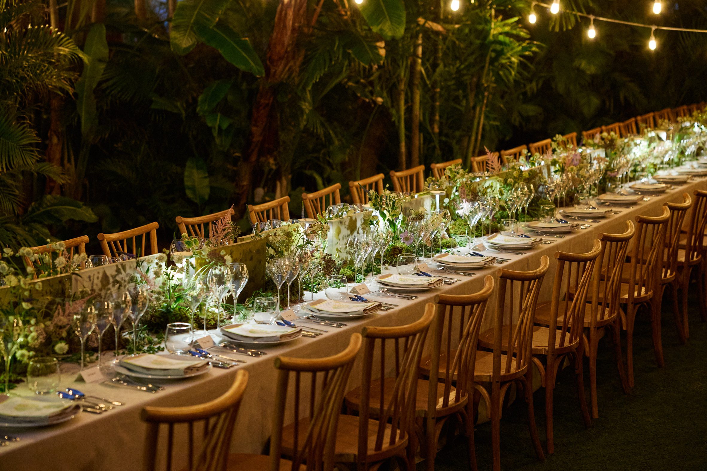 long dinner table set within tropical foliage for perrier-jouët’s banquet of nature event