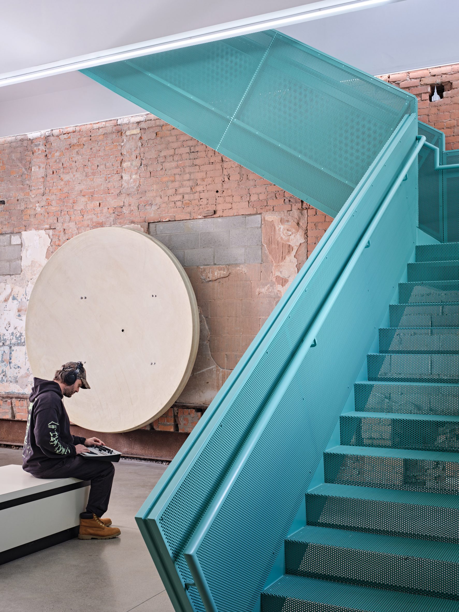 a perforated metal staircase painted a bold aqua colour