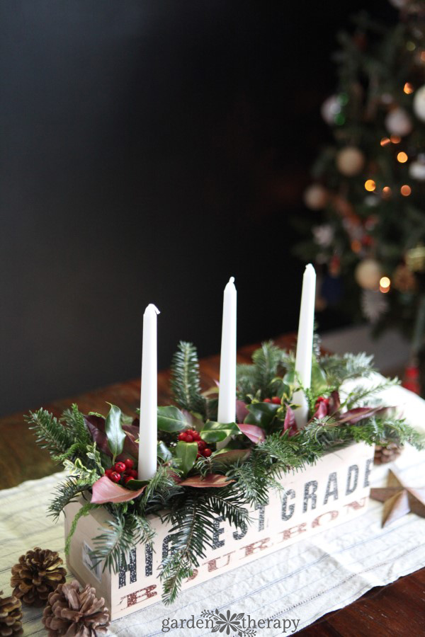 a rustic and natural christmas candle centerpiece planter can be used as table decor, fireplace mantle, or even outdoors on the porch. see the diy.