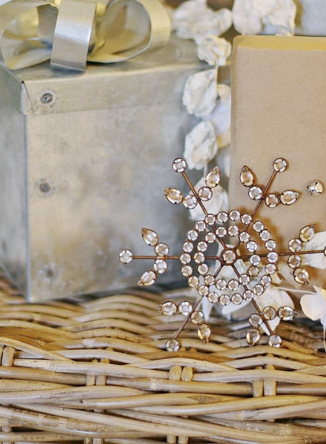 the christmas ornament that started it all 18 a sparkling brooch with a leaf design rests on a woven surface, surrounded by white flowers and a silver box, with a ribbon and beige gift box nearby.