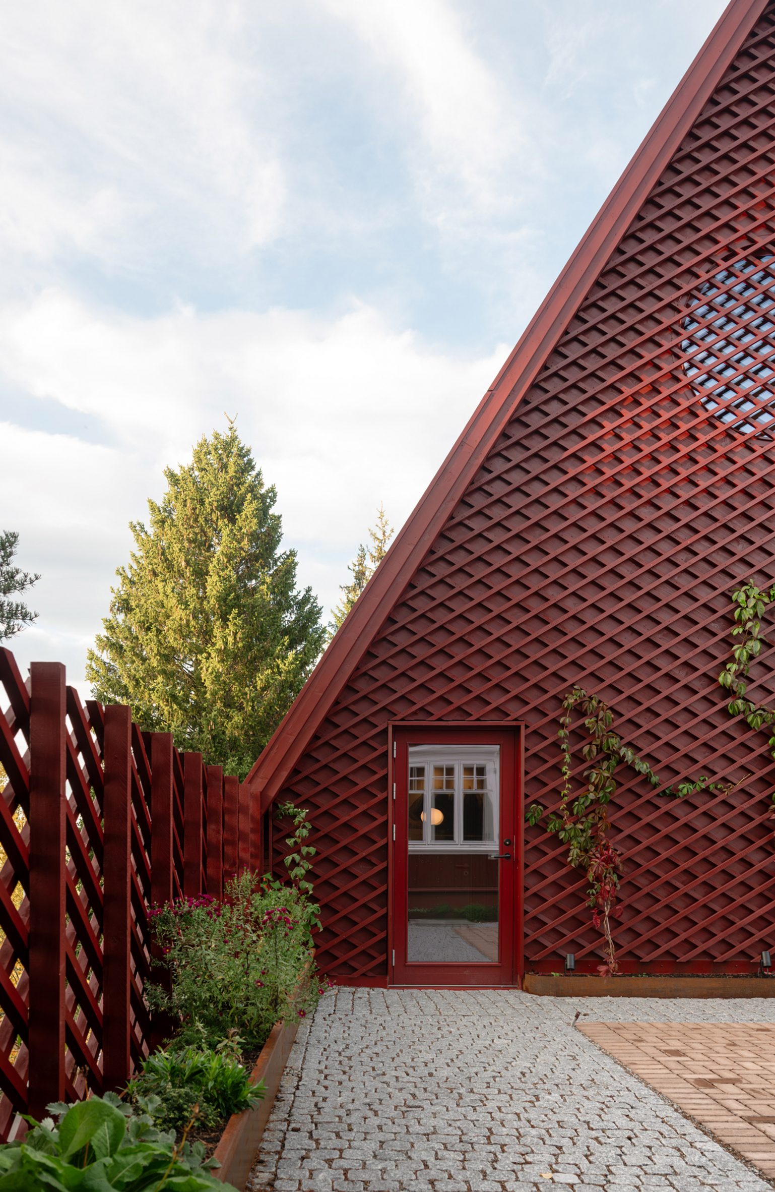 extension with red latticework facade