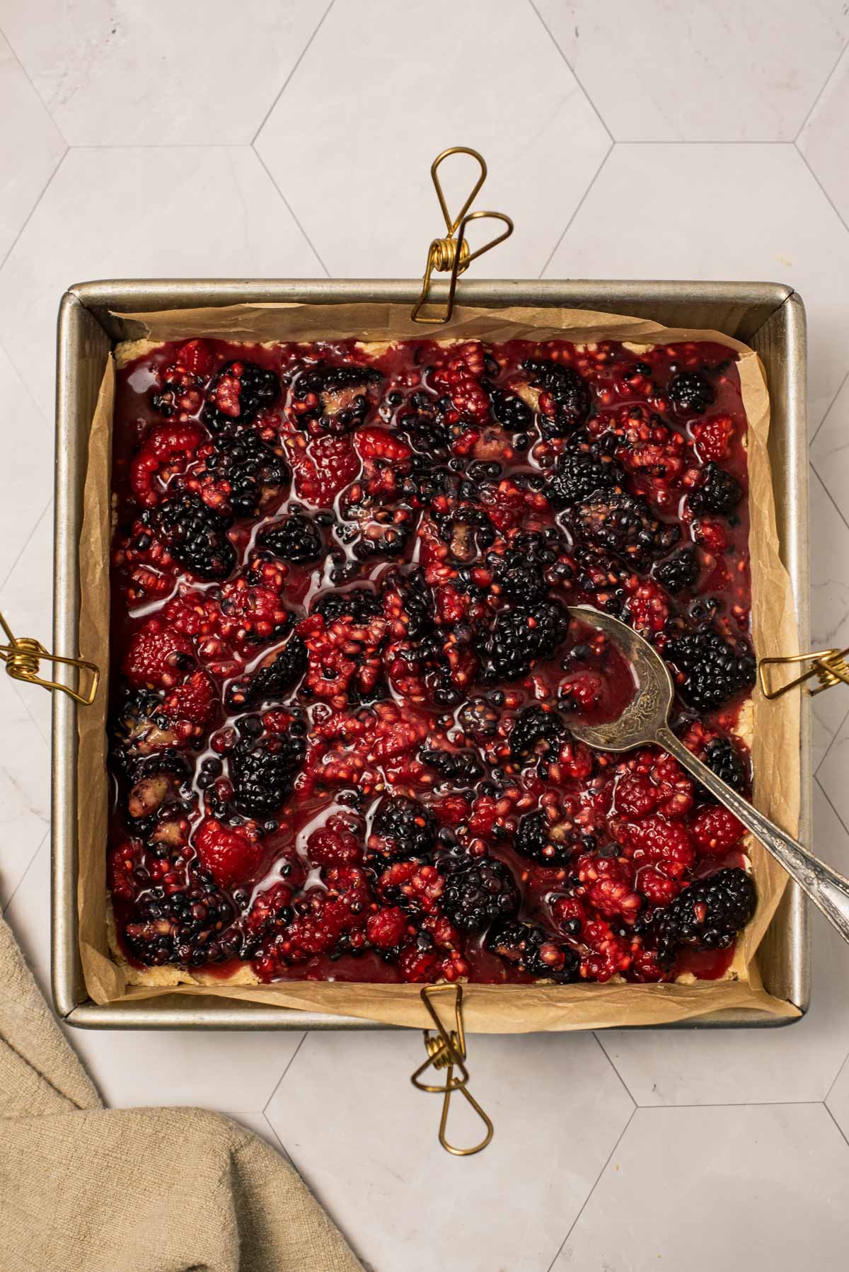 mixed berries in a square baking pan with parchment inside