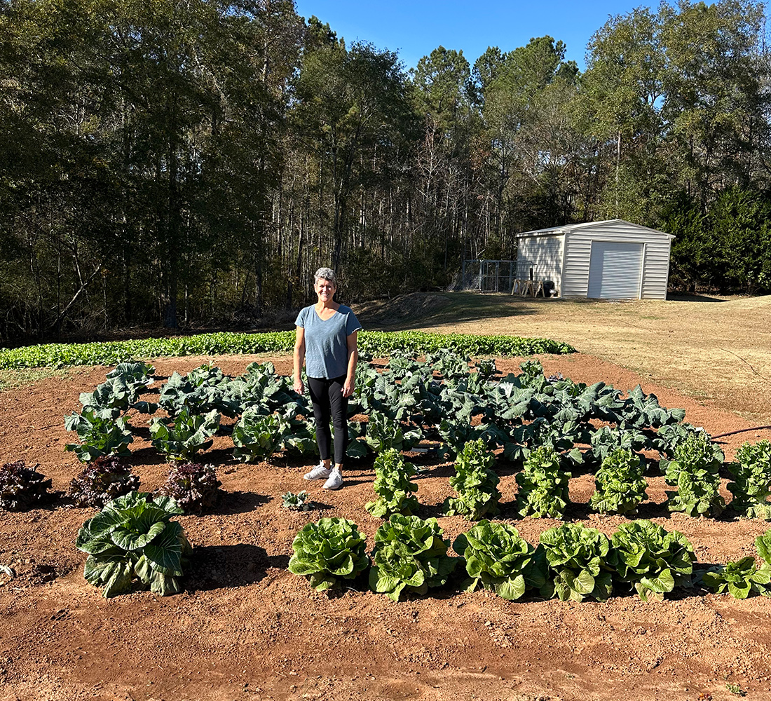 gardener standing in her vegetable garden
