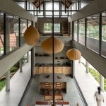 Concrete columns frame open living spaces of Indian home by Taliesyn