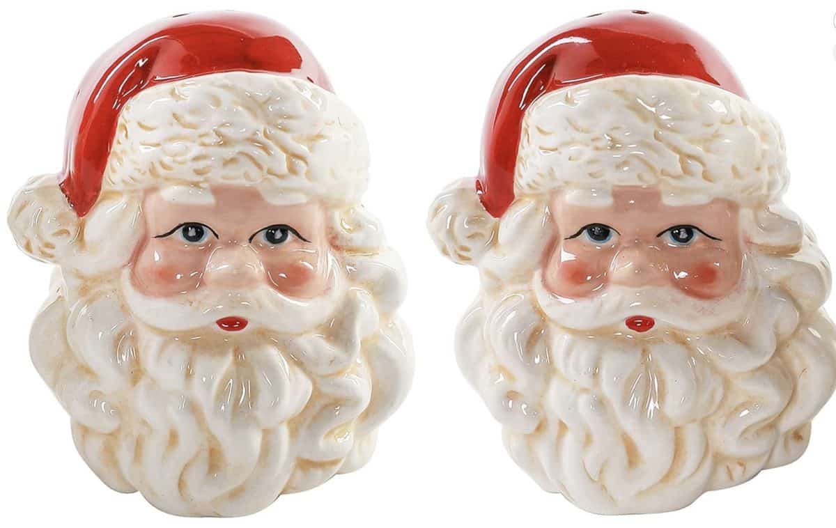 diy christmas tassel simple stepbystep tutorial 34 two ceramic salt and pepper shakers shaped like santa claus heads, featuring red hats, white beards, and rosy cheeks, placed side by side against a white background.