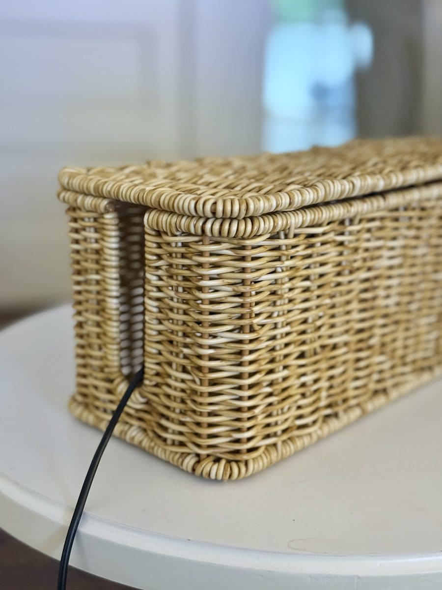 10 unexpected organizing ideas you may not have thought of 1 a rectangular wicker basket with a lid sits on a round white table. a black electrical cord runs into one end of the basket, suggesting it is used to store or hide cables.
