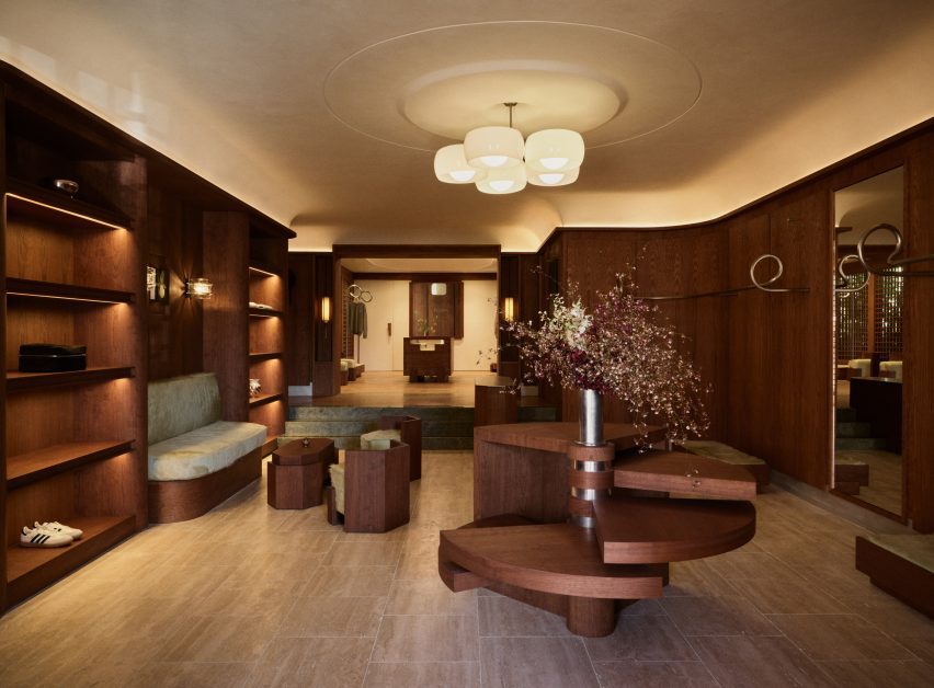 a lounge area including looping metal clothes rails and pale-green upholstered seating