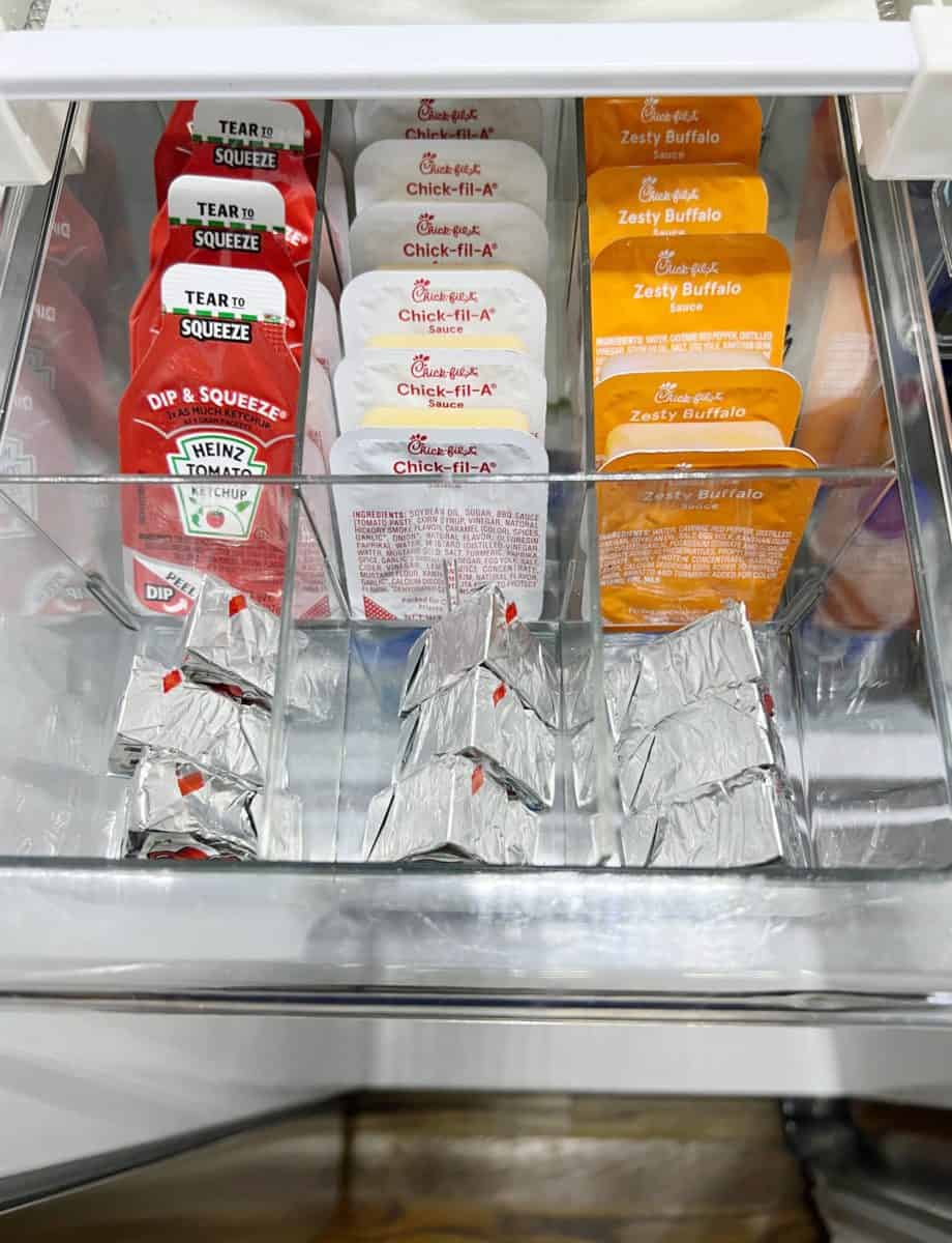 10 unexpected organizing ideas you may not have thought of 8 a fridge drawer neatly organized with a variety of sauce packets including ketchup, chick-fil-a sauce, and zesty buffalo sauce organizing products.