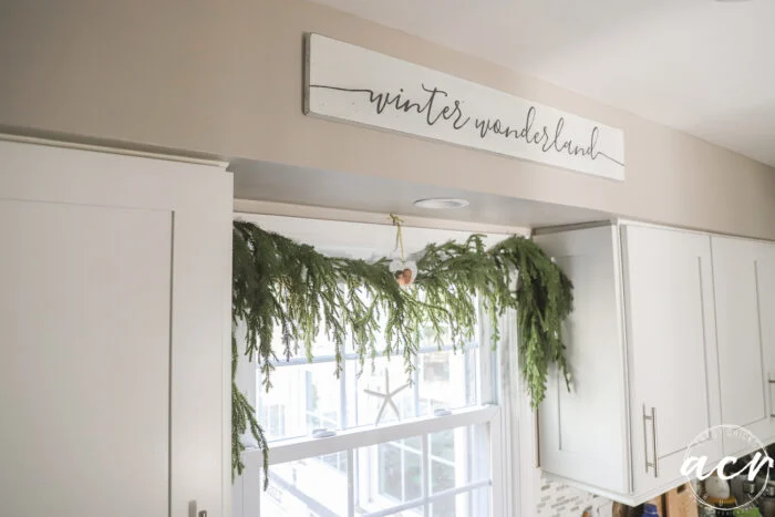 winter wonderland sign above window with greenery draped over window