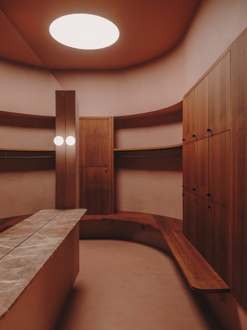 changing room with rounded skylight and wooden lockers