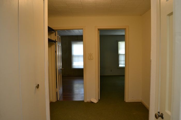 hallway with original hardwood floors hidden under green carpet