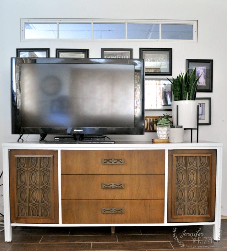 ways to repurpose china cabinets 26 a flat-screen tv sits on a mid century modern furniture makeover console with three central drawers and two patterned side cabinets; framed photos and potted plants are arranged behind and beside the tv.