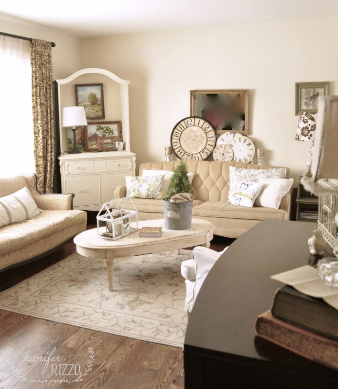 ways to repurpose china cabinets 23 a cozy living room in this small house tour features beige furniture, a patterned rug, decorative clocks, framed art, and a potted plant on a white coffee table. natural light streams through the curtained window.