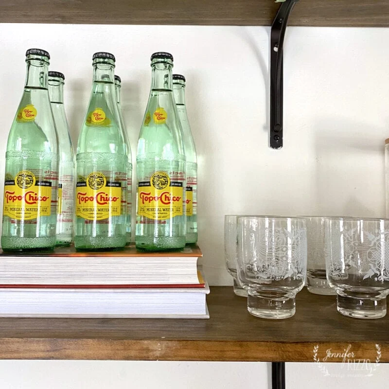 different ways to use vintage books in decorating 13 vintage glasses and topo chico water on open shelving