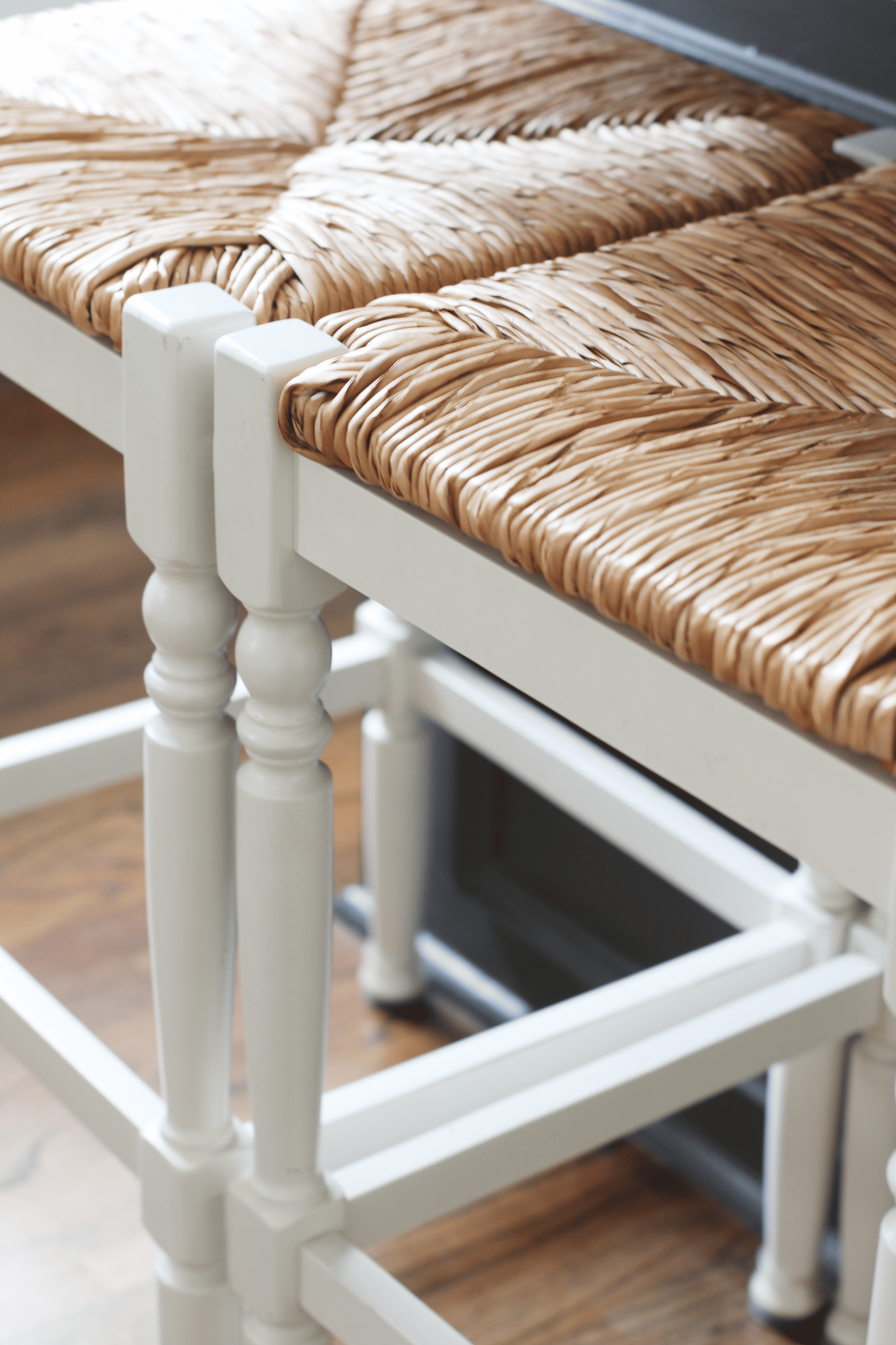 elegant white wooden chairs with woven rattan seats, showcasing the beauty of classic home design details, perfect for how to decorate a kitchen island.