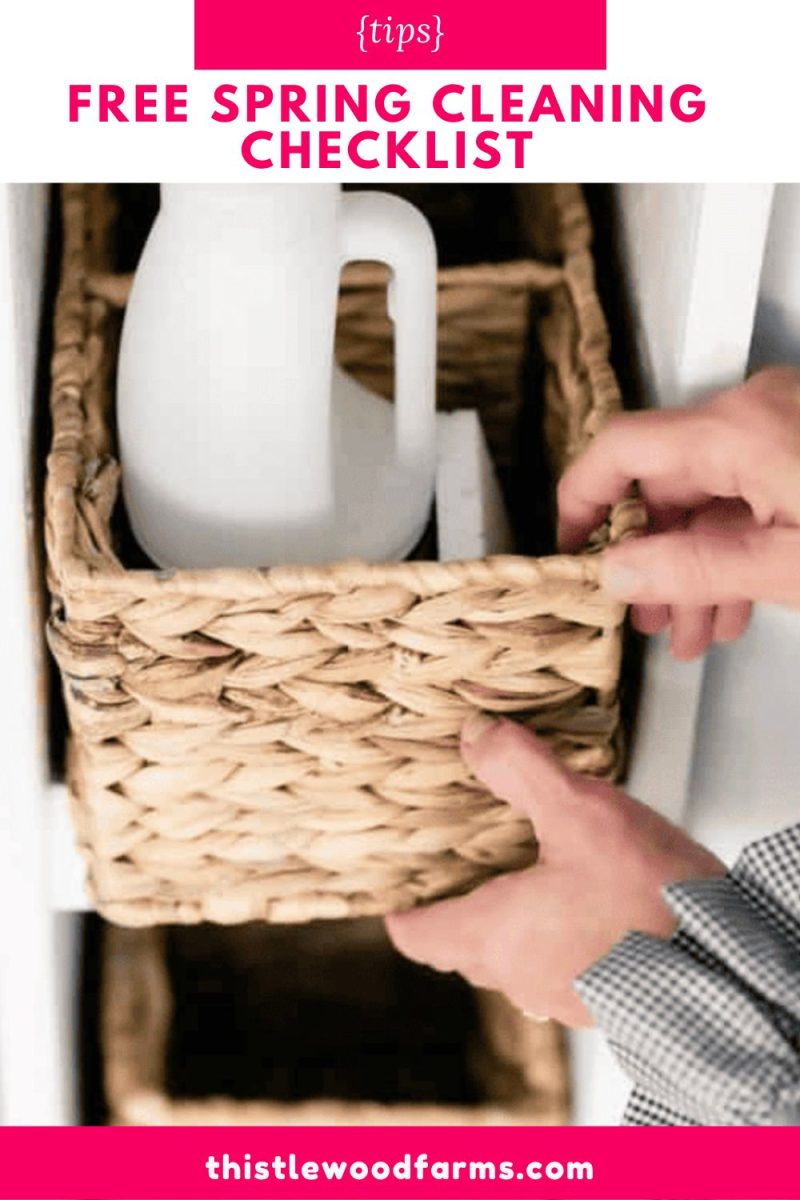 a person’s hands organizing a woven basket on a shelf, with a white spray bottle inside. text above reads "free spring cleaning checklist" and at the bottom, "thistlewoodfarms.com—filled with cleaning tips for the house.