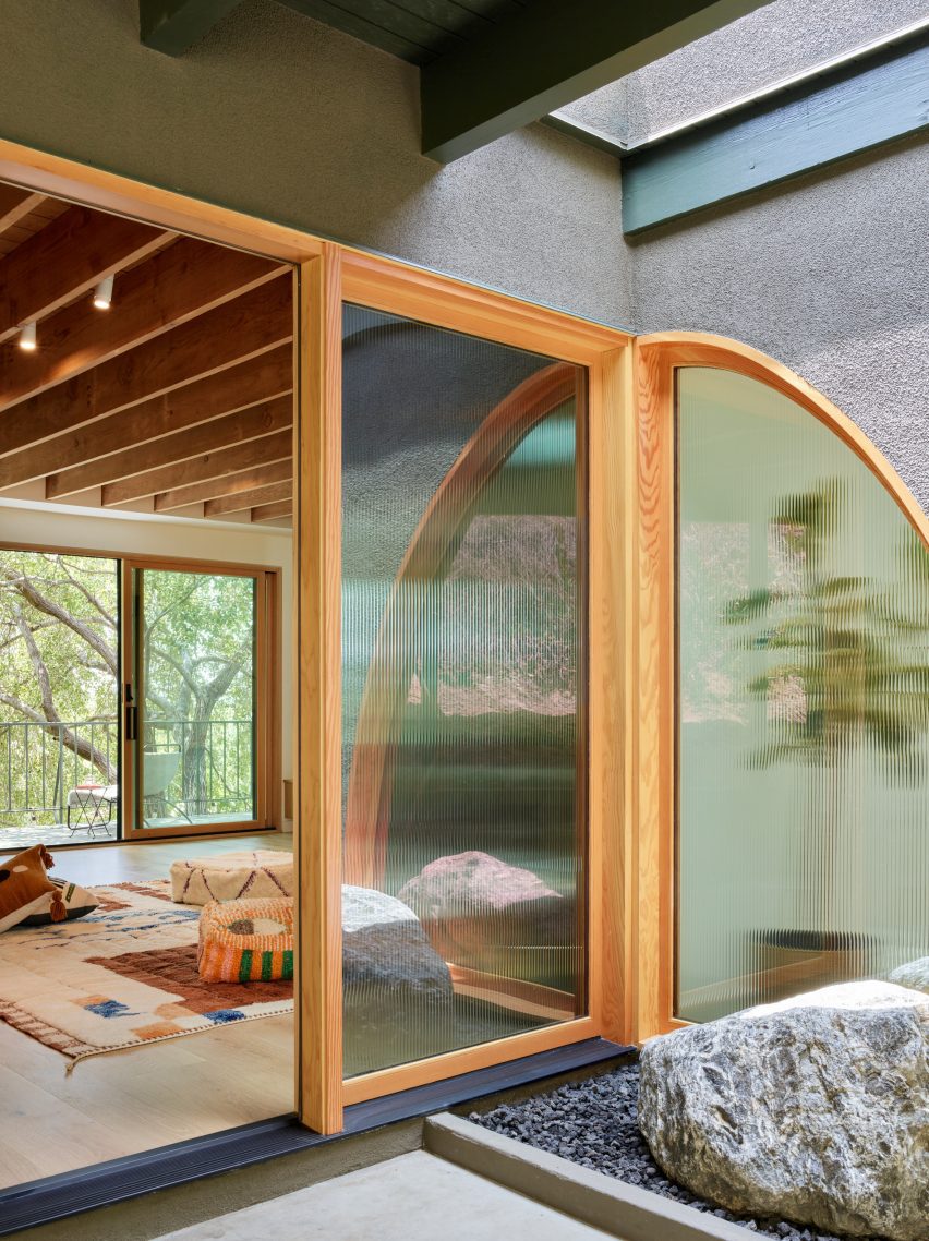 Open front door to a home, with fritted glass windows beside it