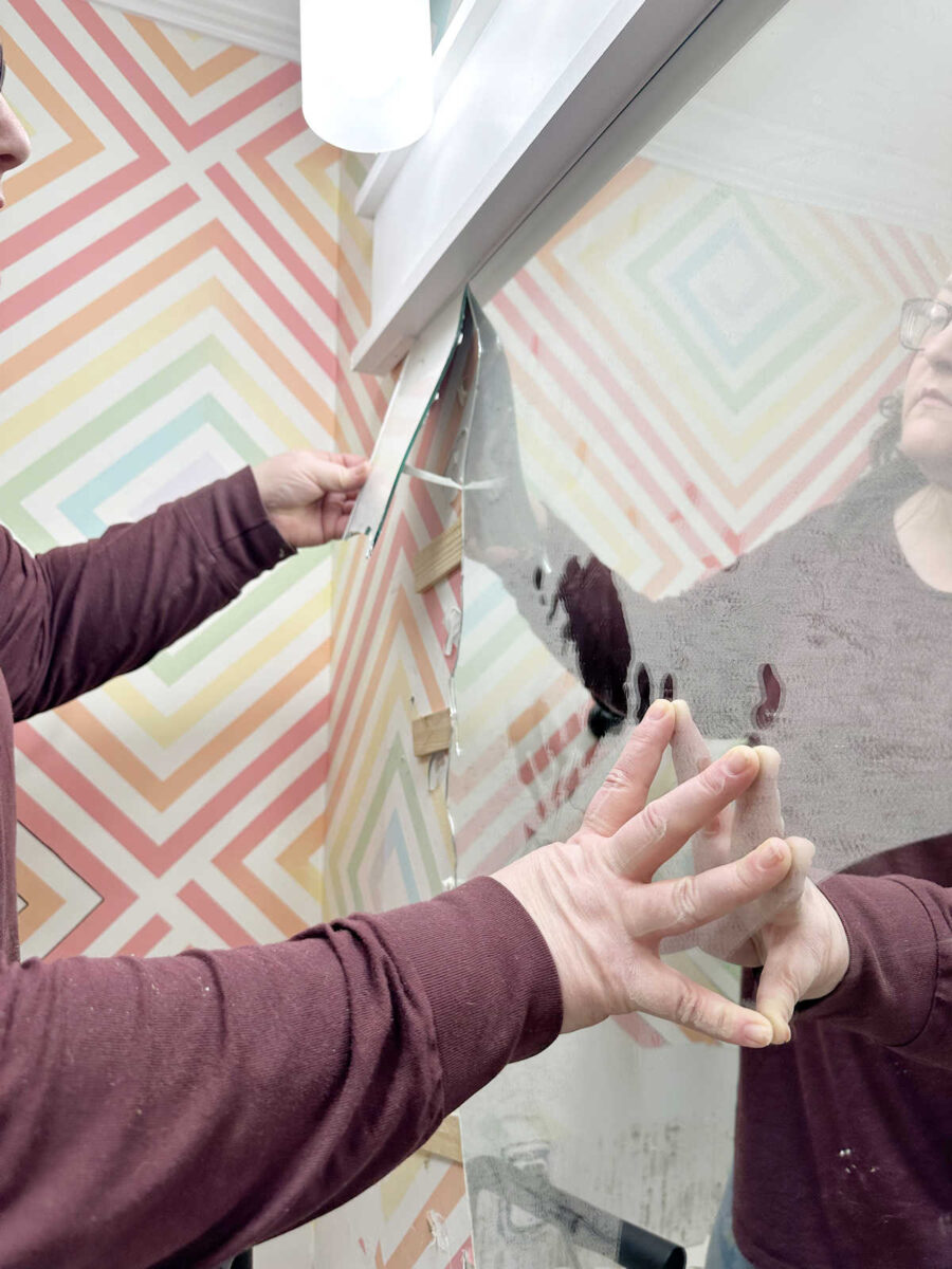 studio bathroom - mirror removal and wall prep 2 removing a bathroom mirror that's glued to the wall using a heat gun and shims