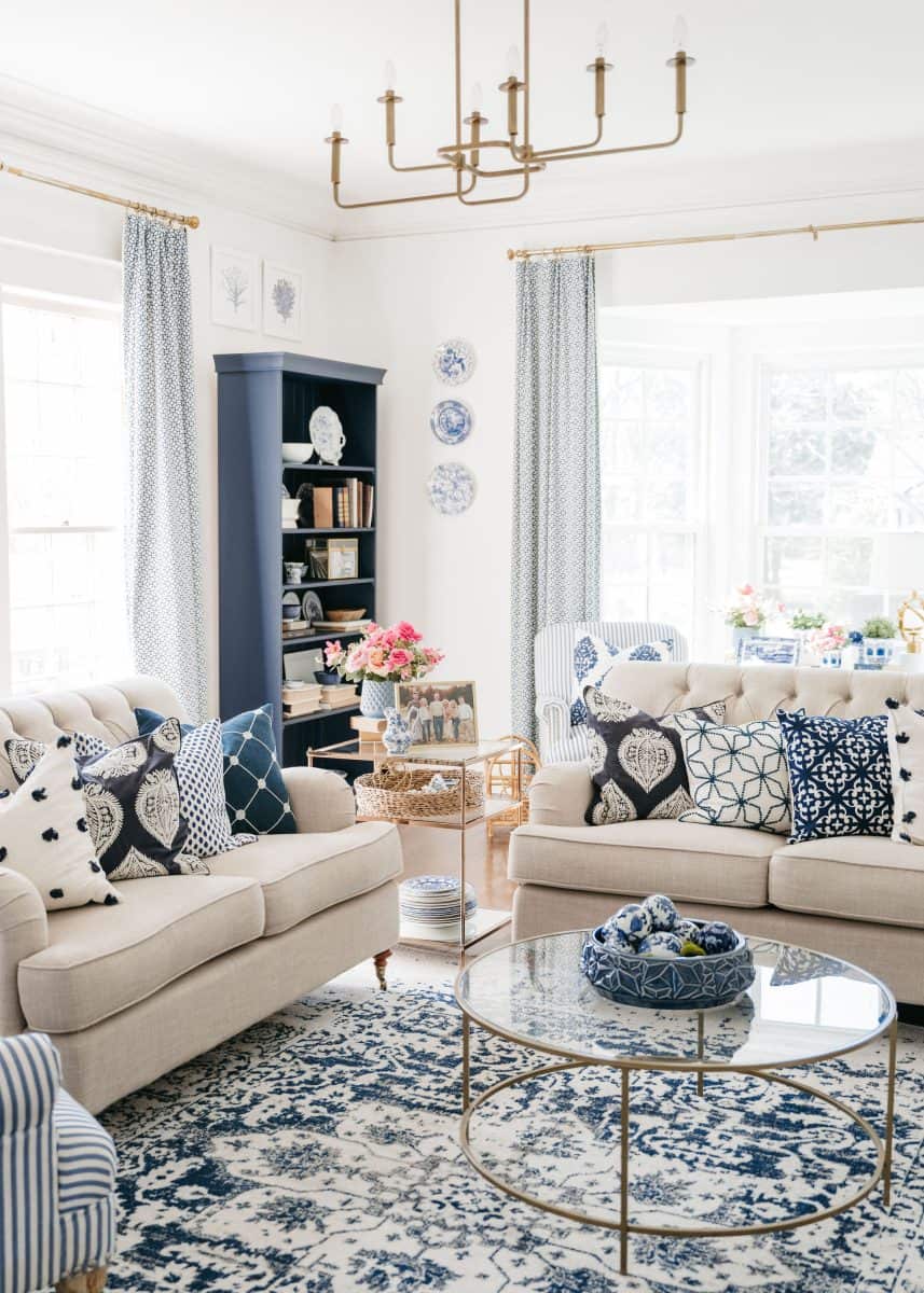 how to mix patterns with blue and white 13 a bright and elegant living room featuring a blue and white color scheme, with matching patterned cushions and decor, set against a backdrop of crisp white walls and natural light.