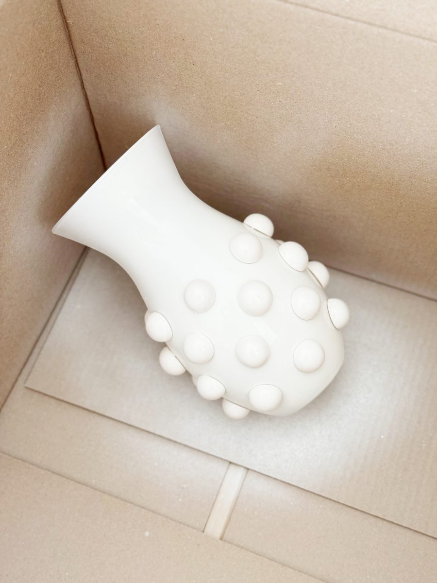 diy hobnail vase that looks like vintage milkglass 39 a white ceramic vase with raised round bumps lies on its side inside an empty cardboard box.