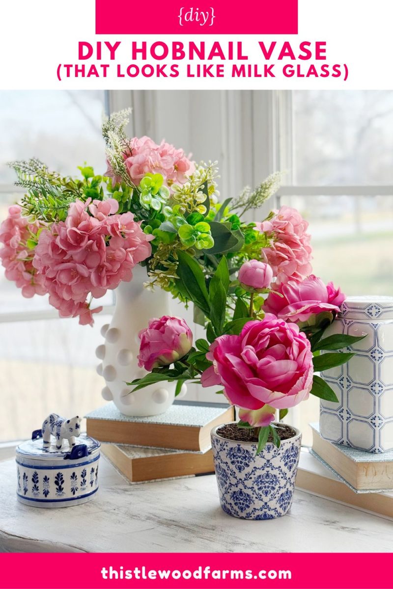 diy hobnail vase that looks like vintage milkglass 45 two floral arrangements in decorative vases are on a table by a window. one is a diy hobnail vase in white, holding pink flowers. the other is blue and white, holding peonies. decorative boxes and books complete the charming display.
