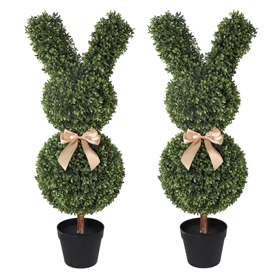 two artificial topiary plants shaped like bunnies, each with a round head and body, upright ears, a pink ribbon bow around the neck, and placed in small black pots.