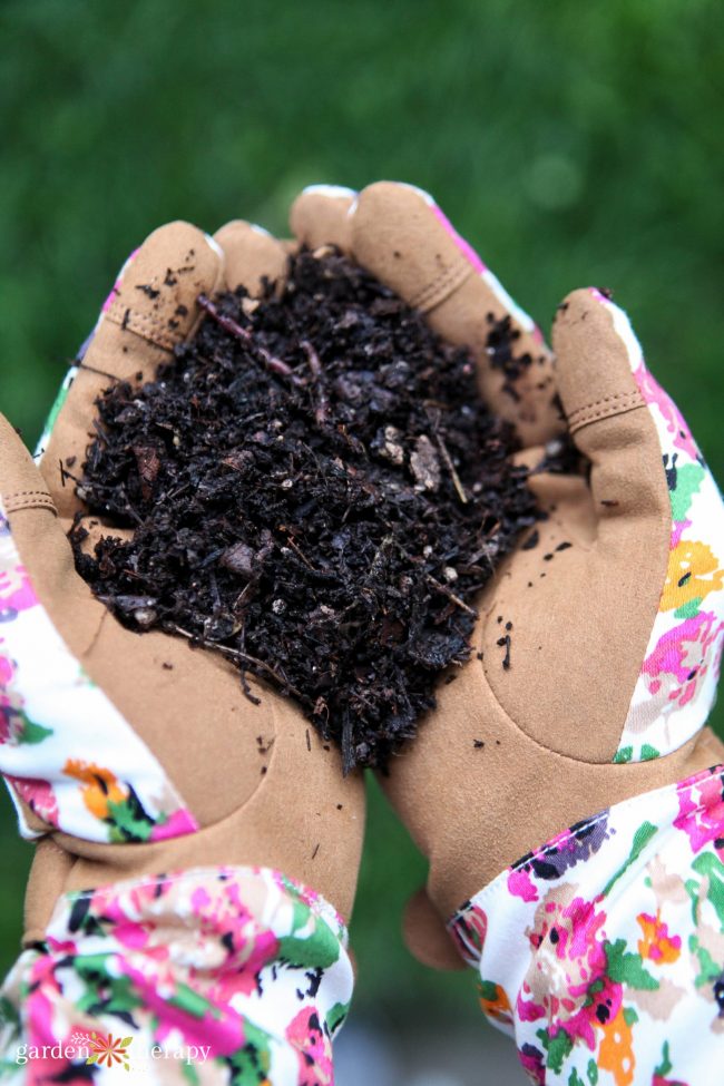 make compost tea with this diy home brewer 19 woman with floral gloves holding soil mingled with compost tea in her hands