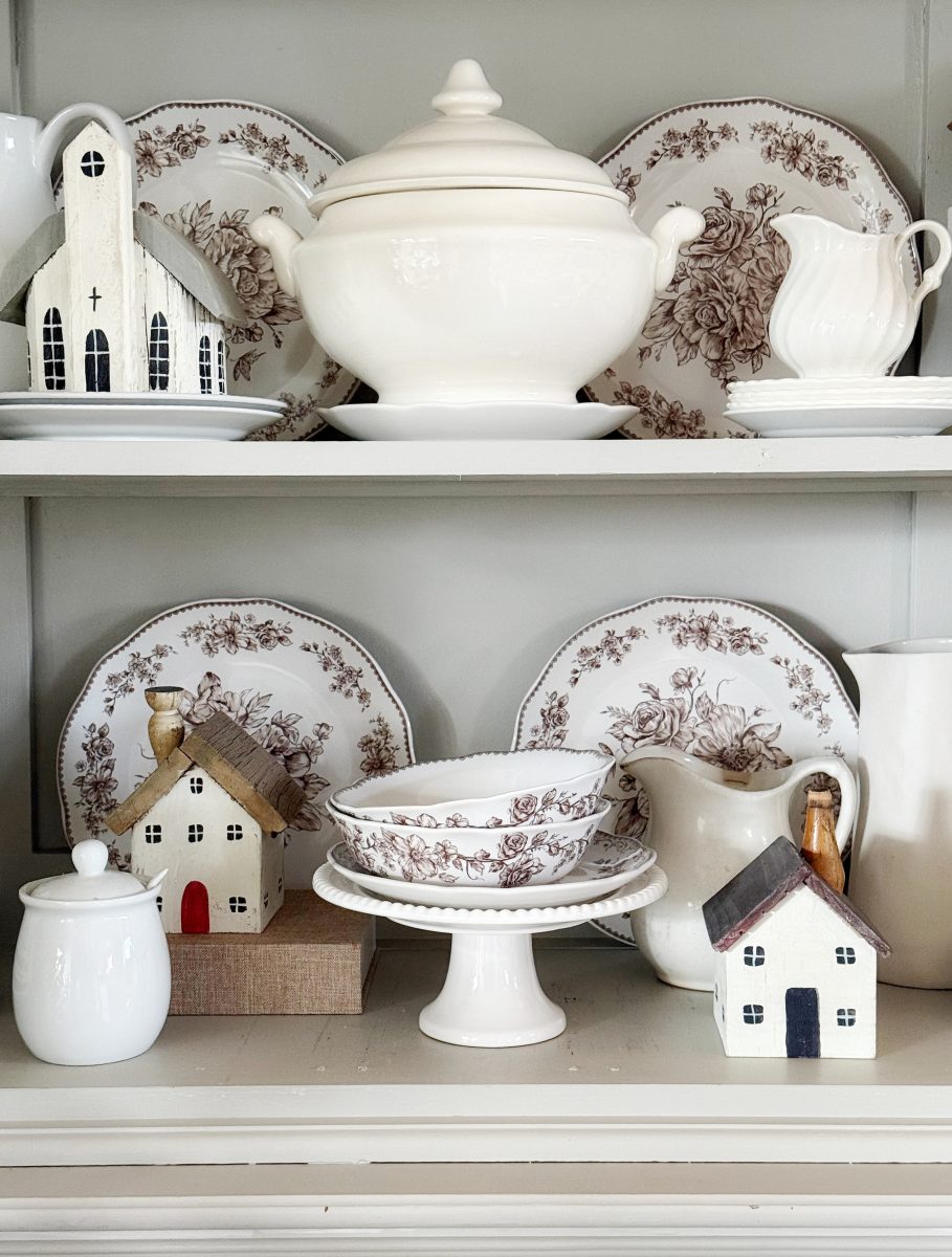 7 simple steps to style a hutch 36 style a hutch with white and floral-patterned china plates, bowls, a soup tureen, decorative ceramic houses, and a white sugar jar—all arranged neatly for a cozy, vintage look.