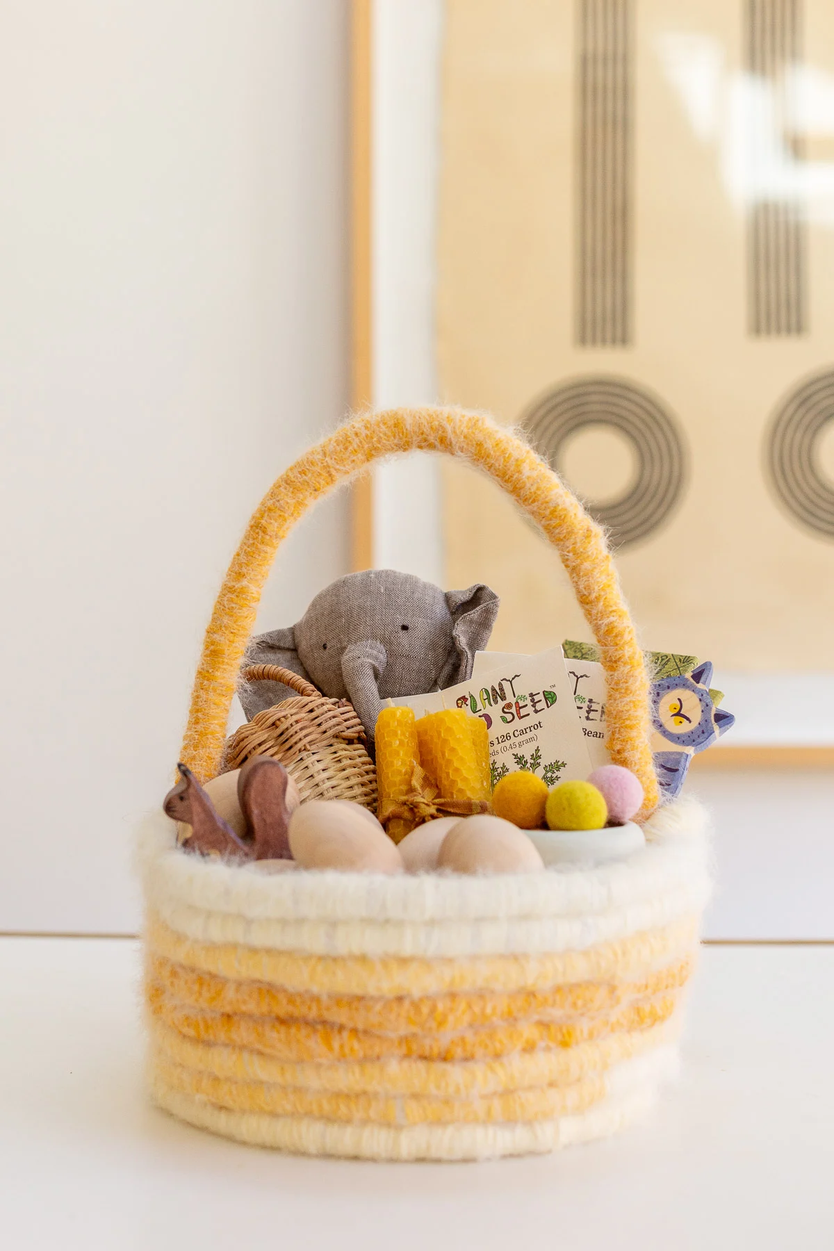 pastel easter basket with baby and kid items inside, in neutral colors