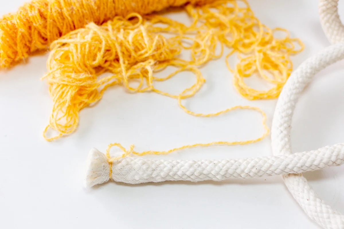 yellow yarn being wrapped around cotton cording