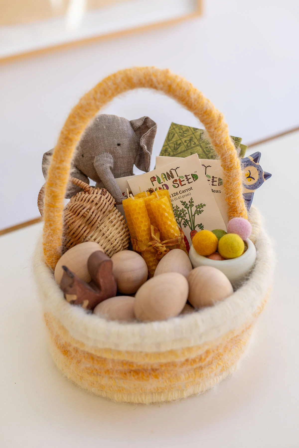handmade easter basket in pastel color with wooden toys and other small gifts for kids inside