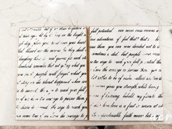 two white boards are displayed side by side on a marble surface, each covered with cursive, black handwritten text. the text on this easter edition seems partially smudged or faded, making it difficult to read in full.