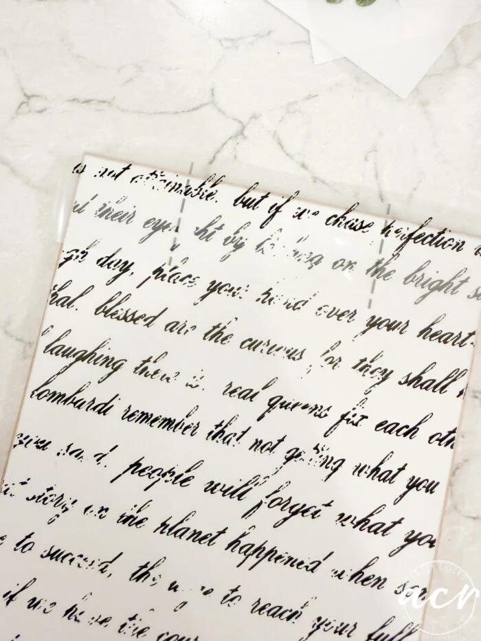 a sheet of white paper with cursive black script, partially faded and distressed, lies on a white marble surface—an easter edition by flipping smalls. some words are missing or hard to read, giving it a vintage, worn effect.