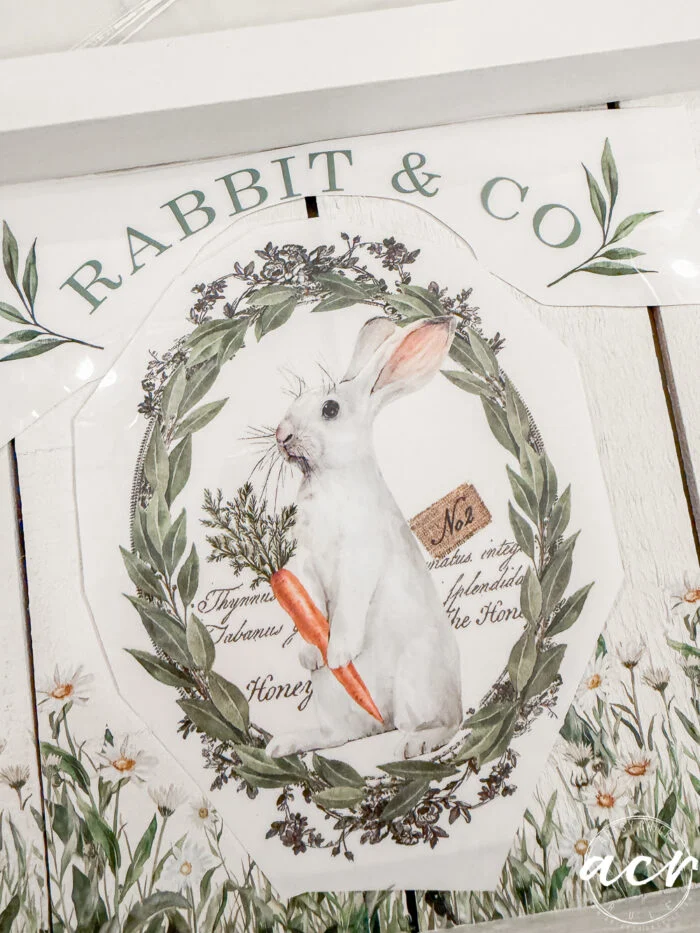 a vintage-style illustration of a white rabbit holding a carrot, framed by a green leafy wreath, with "rabbit & co" above and botanical accents—part of the flipping smalls easter edition collection.