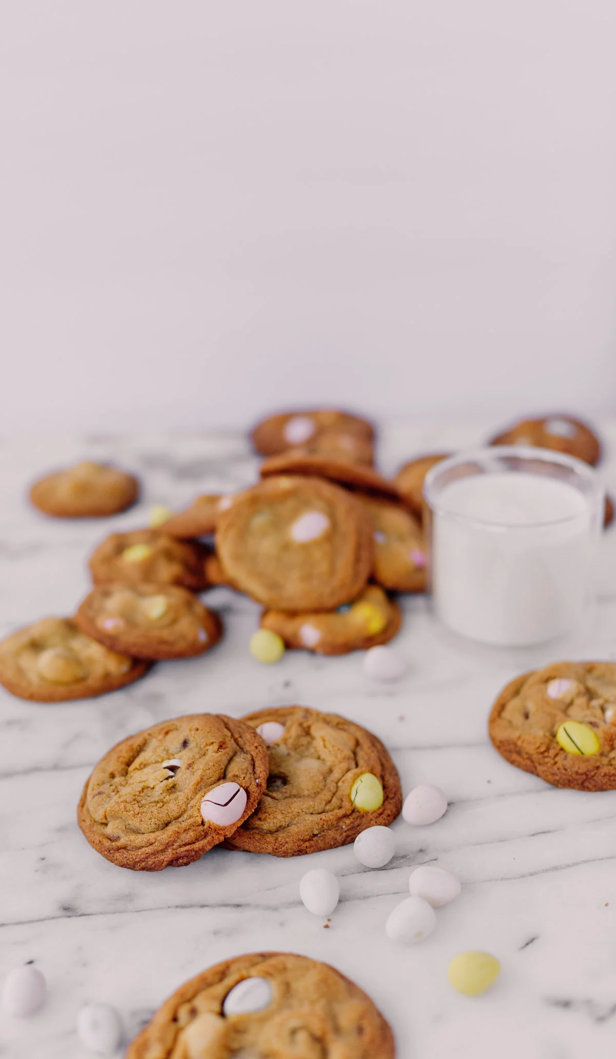 cookies on a marble counter with easter candy and glass of milk